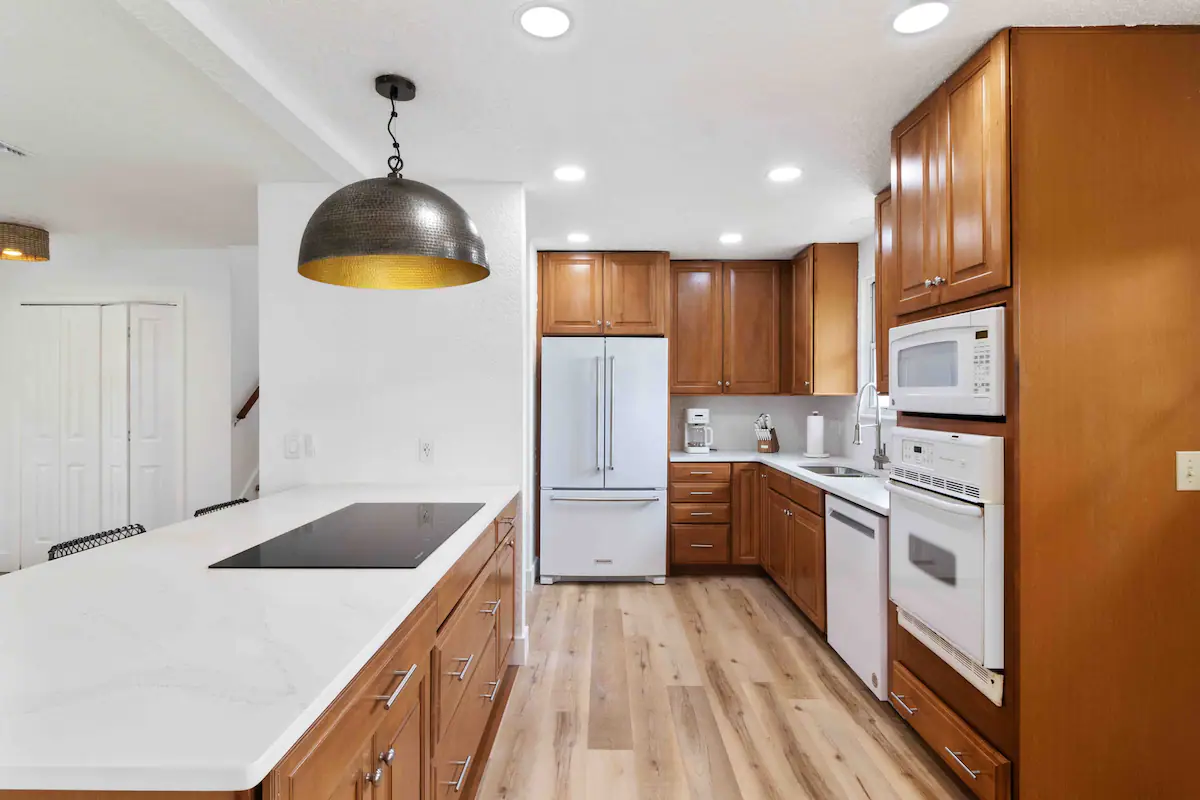 Fully functioning kitchen with ample plates, cups, & silverware.